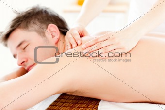 Positive young man having a back massage 