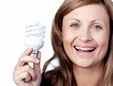 Cheerful woman holding a light bulb 