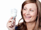 Smiling young woman holding a light bulb 