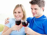 Affectionate couple drinking wine sitting on a sofa