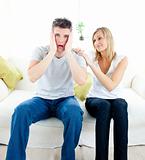 Shocked man sitting on the sofa with his girlfriend