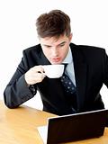 Stressed young businesswoman drinking coffee and using his lapto