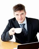 Charming young businessman holding a cup smiling at the camera 