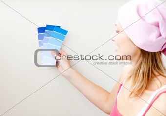Attractive young woman choosing color for painting a room 