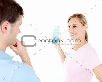 Cheerful woman showing her boyfriend colors for painting a room