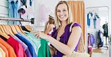 Joyful young woman choosing clothes with her friend