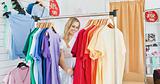 Merry blond woman choosing colorful clothes 