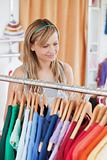 Captivating young woman choosing a colorful shirt 