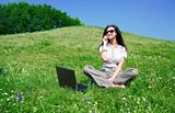Beautiful woman with notebook and mobile phone sit on hill