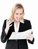 Aggressive businesswoman looking at a newspaper shouting 