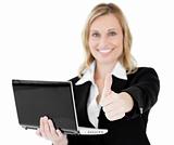 Positve businesswoman holding a laptop  thumb up 