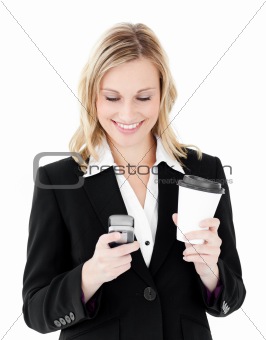 Beautiful businesswoman sending a text holding coffee 