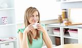 Blond caucasian woman drinking coffee in the kitchen
