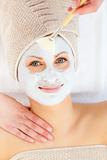 Portrait of a smiling woman having a spa treatment in a health center with white cream