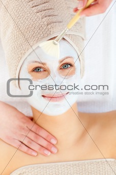 Portrait of a smiling woman having a spa treatment in a health center with white cream