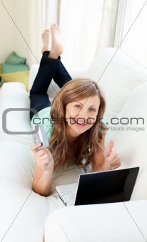 Animated woman with laptop and card on the sofa 