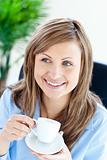 Happy businesswoman holding a cup siiting
