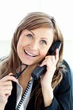 Attractive businesswoman talking on phone holding glasses against white background