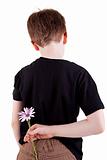 Young boy hiding flowers behind his back