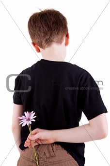 Young boy hiding flowers behind his back