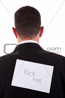 back of businessman, with kick me written in a paper
