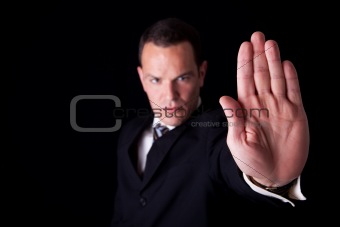 Businessman with his hand raised in signal to stop