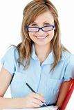 bright woman with glasses writing on a folder
