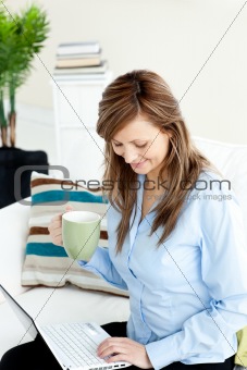 Pretty caucasian businesswoman using her laptop on the sofa