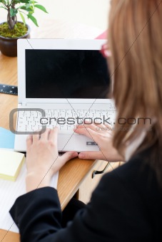 Caucasian blond businesswoman working at her laptop 