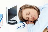 Tired caucasian businesswoman sleeping on her desk 