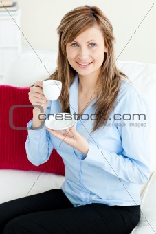 Self-assured blond businesswoman holding a cup 