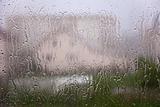 View through window with streams and drops of rain water