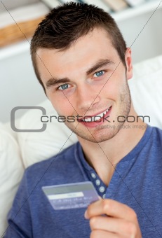 Joyful man holding a card smiling at the camera