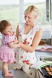 Beautiful mother baking with her daughter together 