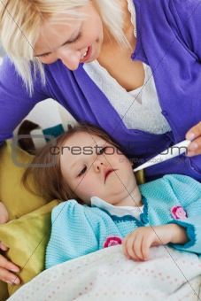 Attentive mother takes her daughter's temperature 