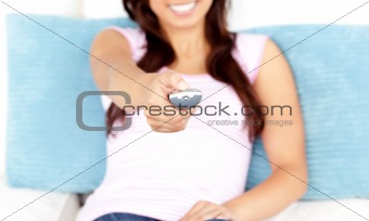 Close-up of an asian woman holding a remote sitting on a sofa 