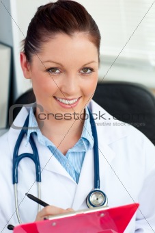 Attractive young female doctor holding a clipboard 