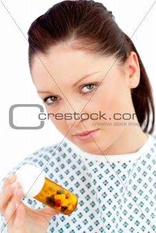Depressed sick woman holding pills looking at the camera