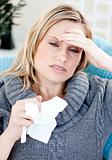 Caucasian woman with headache and tissues at home
