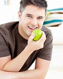 Smiling caucasian man holding an apple looking at the camera 