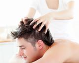 Happy young man receiving a head massage 