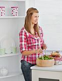 Attractive young woman preparing a salad 