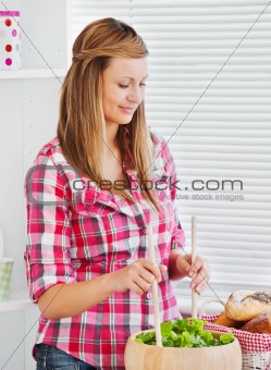 Concentrated young woman preparing a salad 