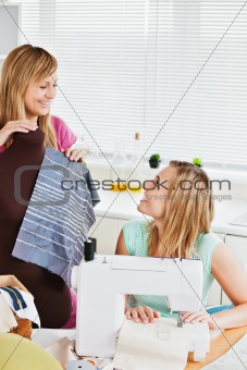 Delighted woman sewing with her friend