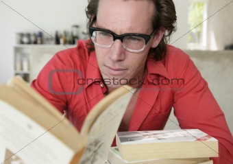 Young man with glasses reading a book