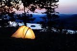 A tent lit up at dusk 