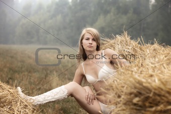 Young sexy woman among the straw.