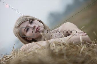 Young sexy woman among the straw.
