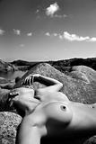 Nude woman on rocks.