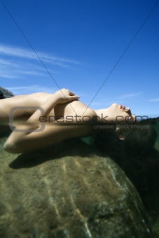Nude woman in water.